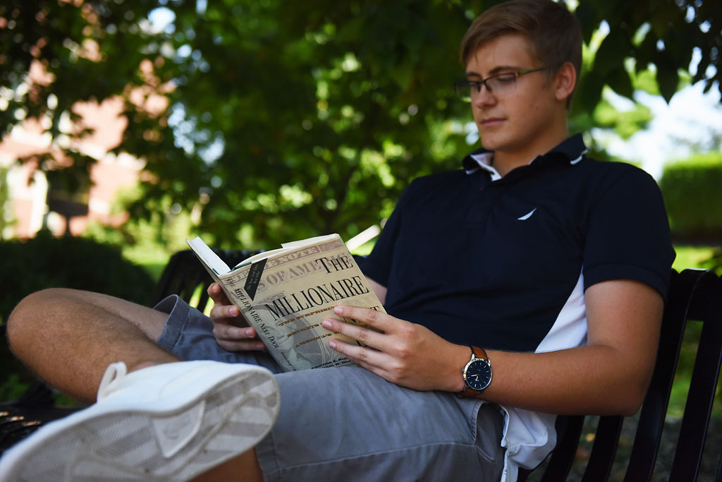 Hunter Bernardi, freshman, reads "The Millionaire" near Francis Quadrangle